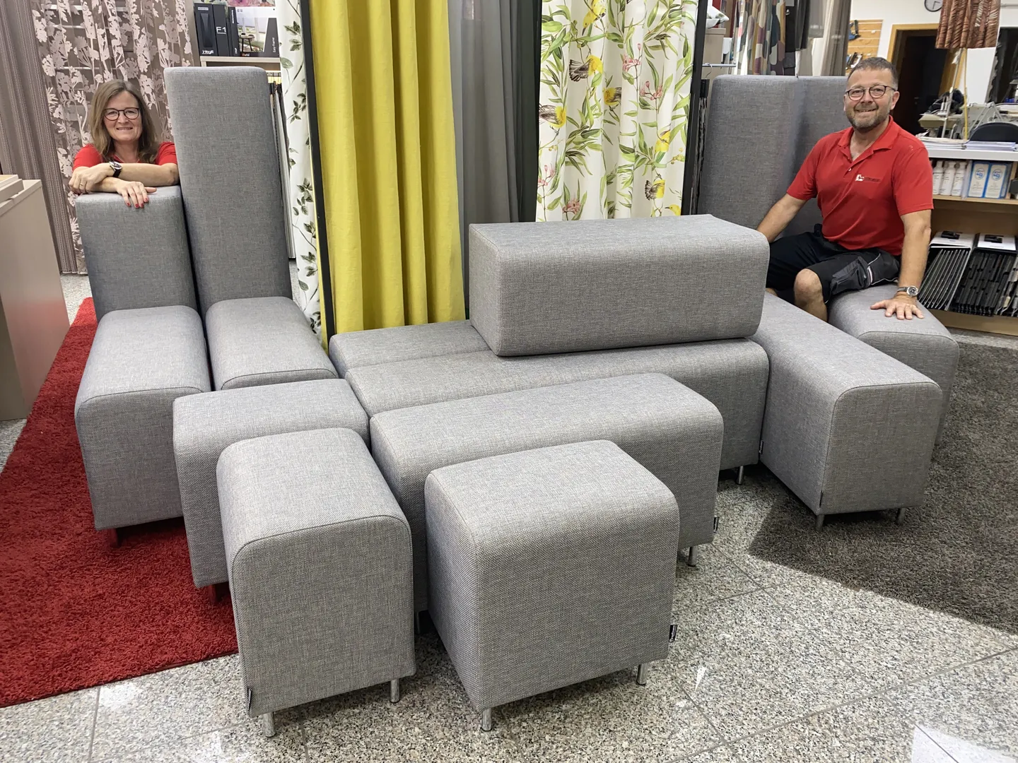 Neu bezogene graue Sessel und Hocker in der Polsterwerkstatt